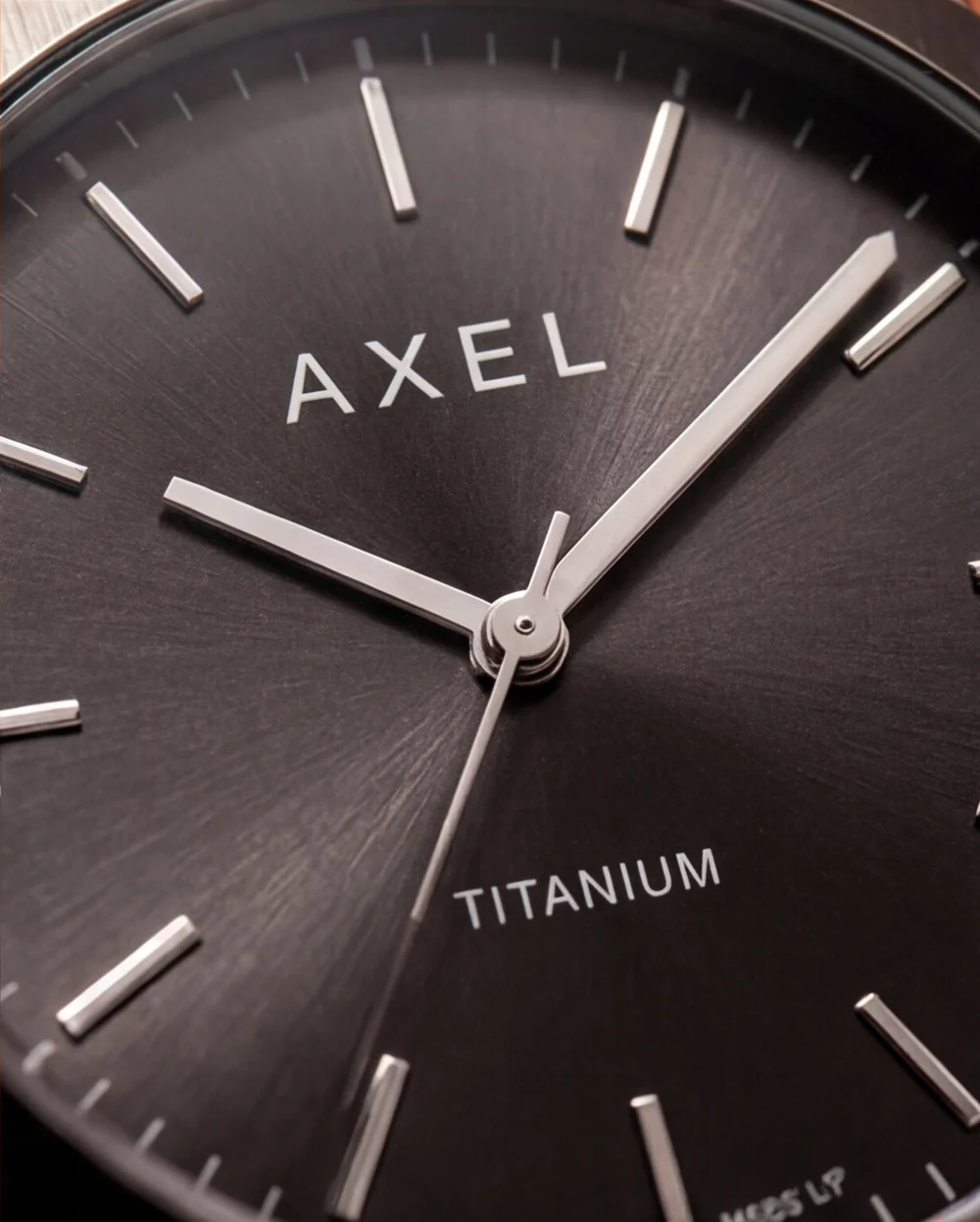 Independent AI-assisted AXEL Titanium watch study: close-up of the grey dial and silver hands.